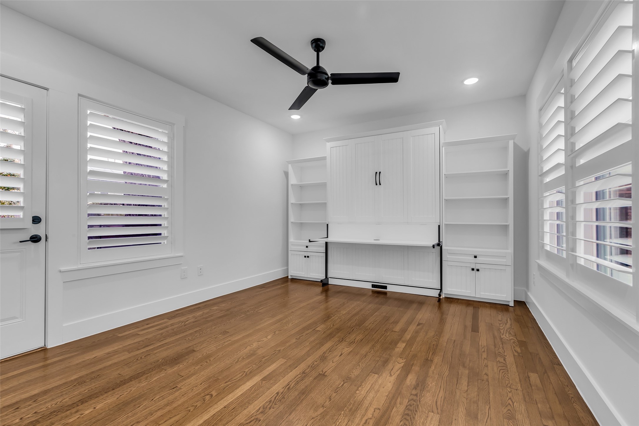 2611 Ruth Street Houston, TX 77004 - Photo 27 of 50 The first-floor bedroom features original hardwood floors and a bright, welcoming atmosphere.
The room includes a built-in wall bed that serves as a desk when the bed is stowed.