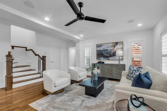 a living room with furniture floor to ceiling window and wooden floor