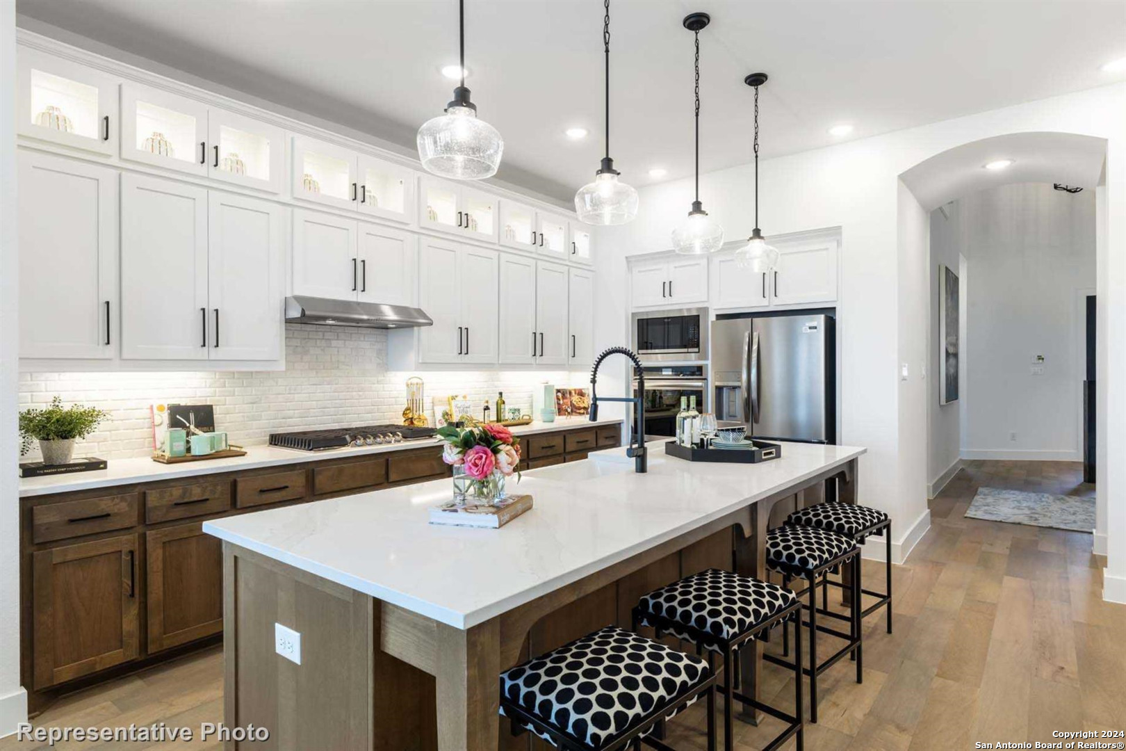a kitchen with stainless steel appliances a table chairs and white cabinets