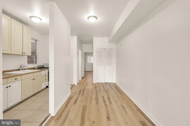 a view of a kitchen with a refrigerator a stove top oven and cabinets