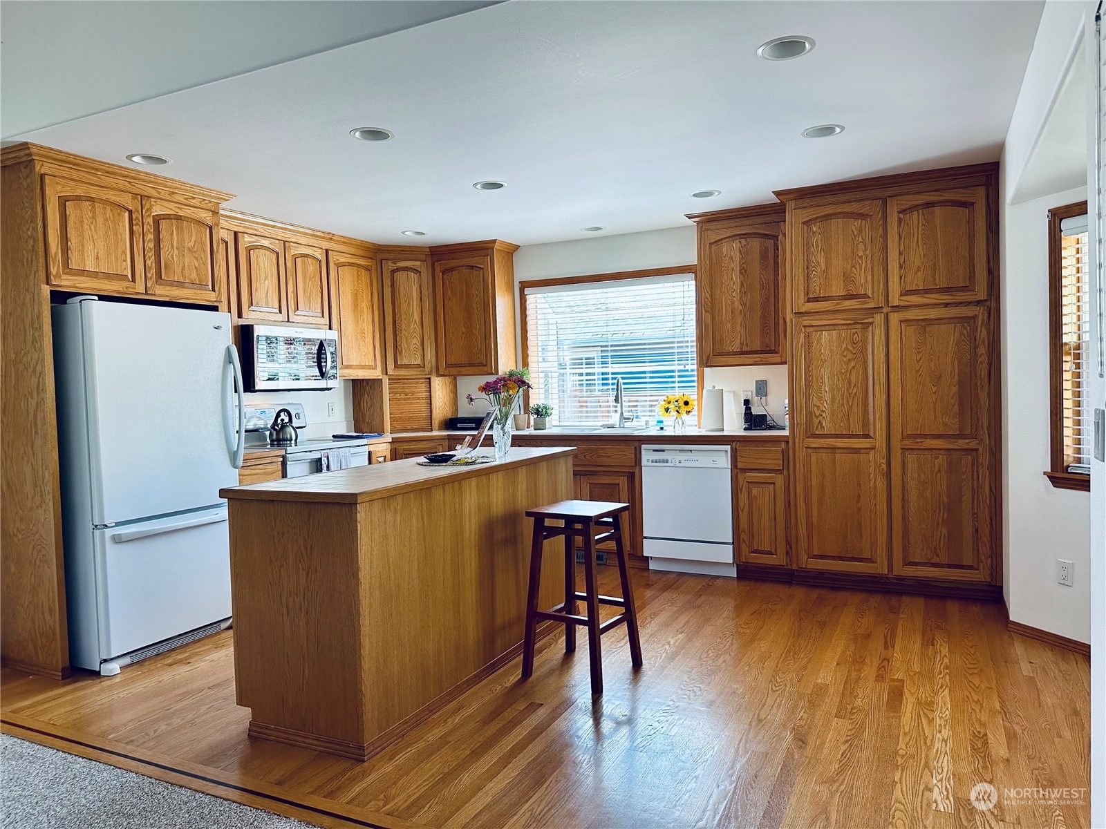 8625 Myrtle Road Northwest Stanwood, WA 98292 - Photo 6 of 23 a kitchen with stainless steel appliances granite countertop a refrigerator a stove a sink dishwasher and a dining table with wooden floor