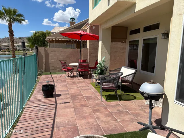 a view of a patio with a dining table and chairs under an umbrella with wooden floor