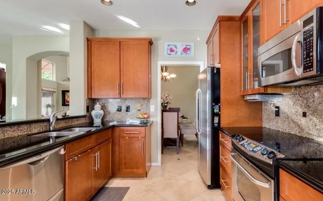 a kitchen with granite countertop a sink stove and refrigerator