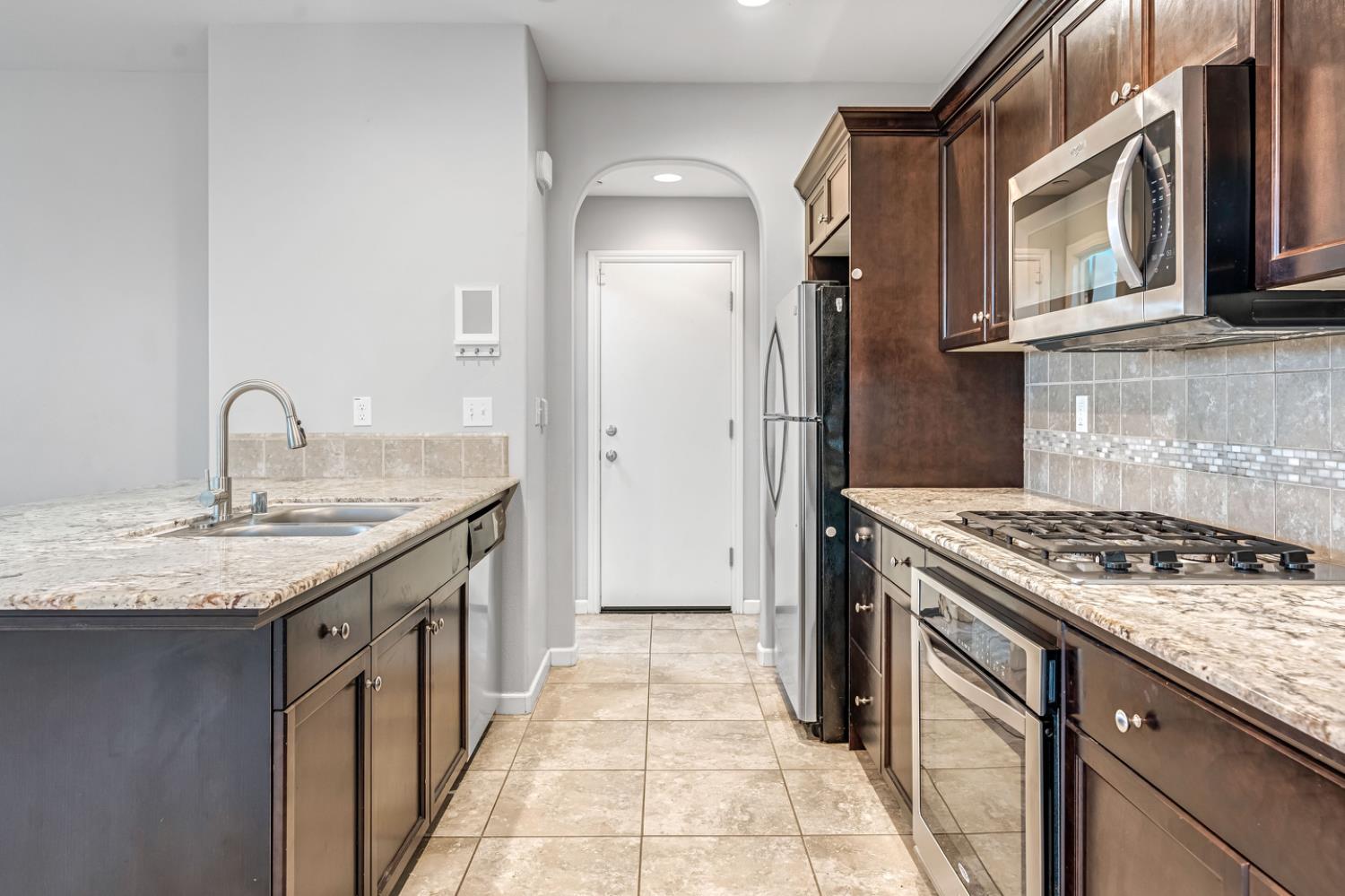 1503 North Reunion Way Clovis, CA 93619 - Photo 14 of 25 a kitchen with stainless steel appliances granite countertop a sink and a stove