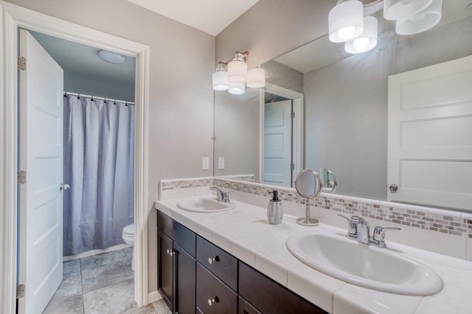 1503 North Reunion Way Clovis, CA 93619 - Photo 5 of 25 a bathroom with a double vanity sink and a mirror