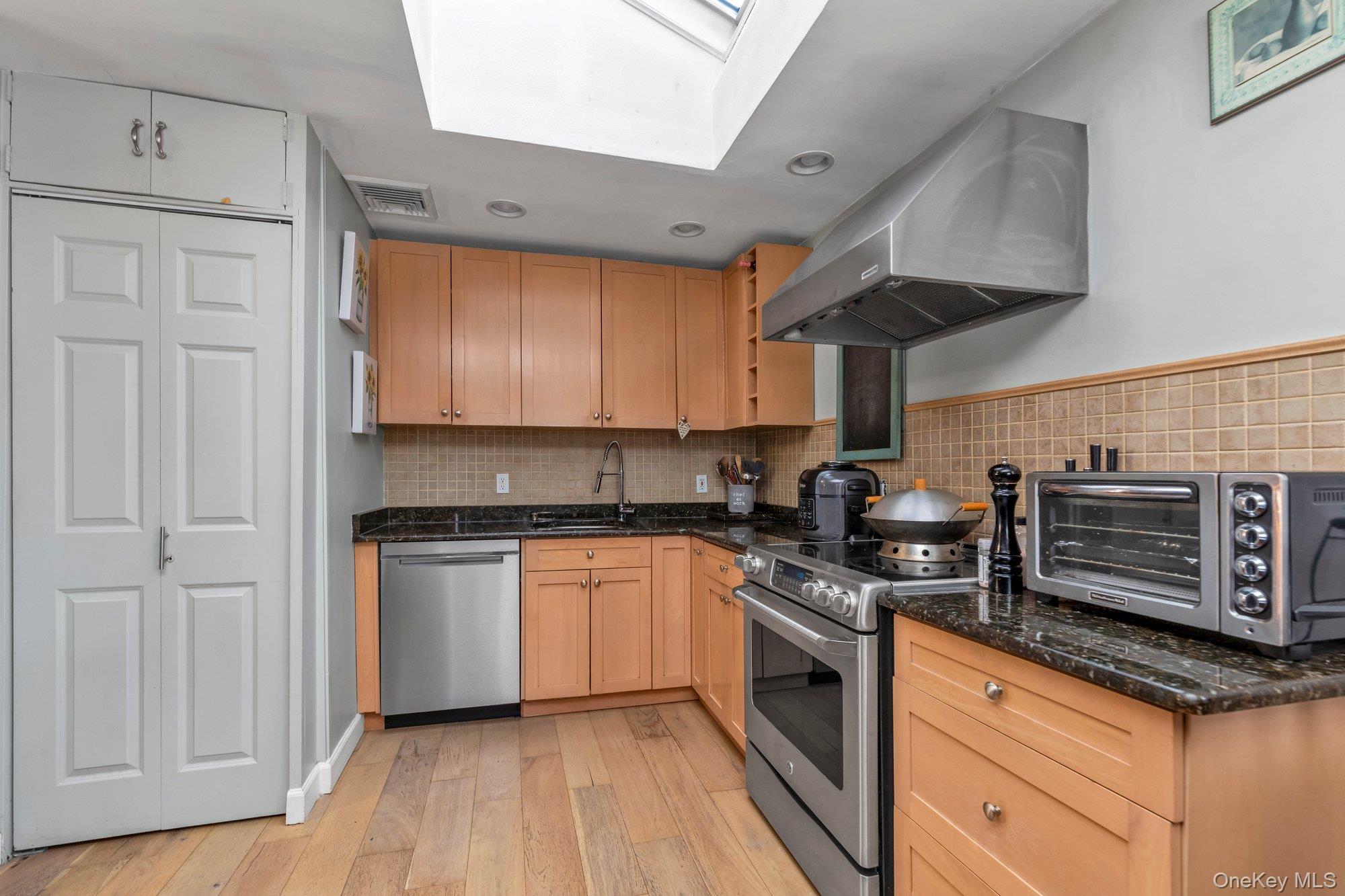 412 Wellington Road East Meadow, NY 11554 - Photo 8 of 15 a kitchen with stainless steel appliances granite countertop a stove a sink and a refrigerator