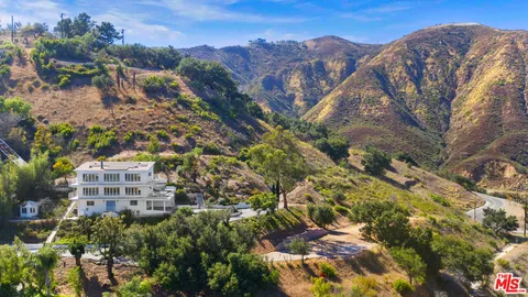 a view of a large building with mountains in the background
