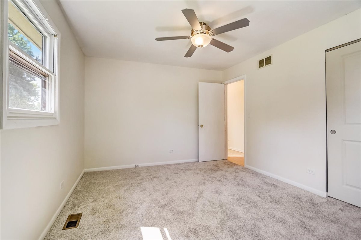 S041 Page Street Winfield, IL 60190 - Photo 15 of 32 an empty room with a ceiling fan and a window