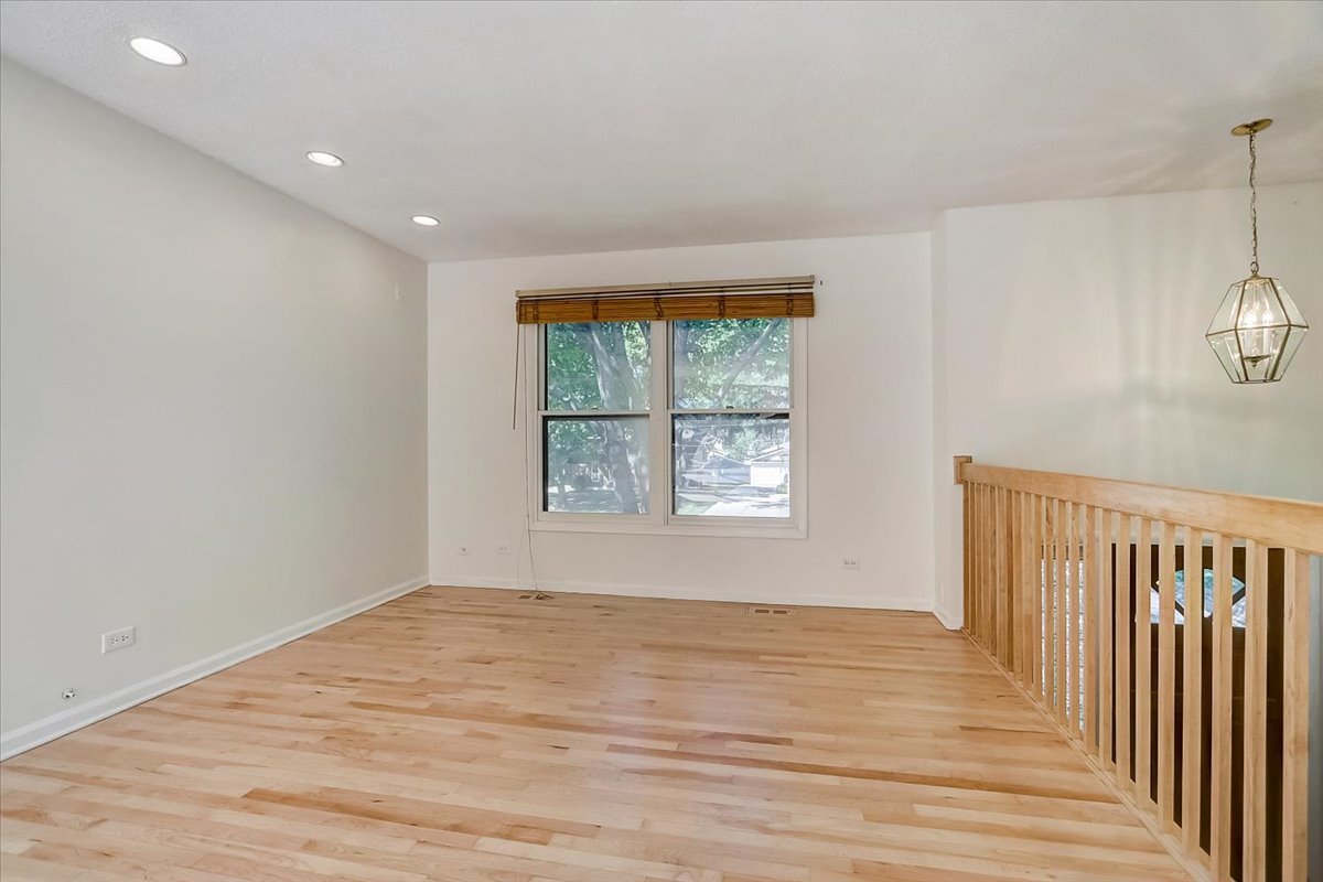 S041 Page Street Winfield, IL 60190 - Photo 3 of 32 a view of an empty room with wooden floor and a window