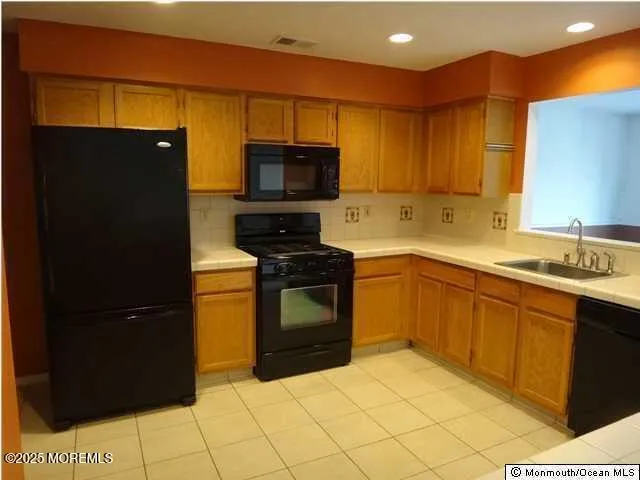 a kitchen with a sink a stove top oven and refrigerator