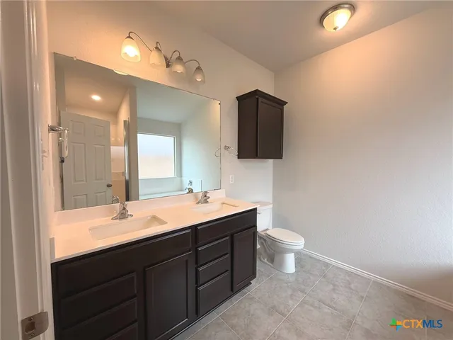 a bathroom with a double vanity sink and a mirror