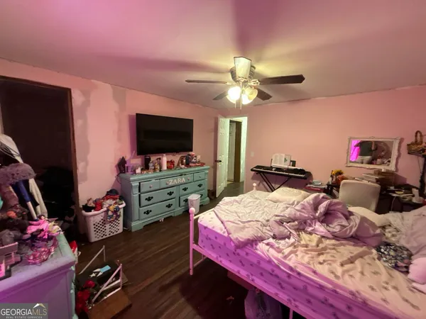 a bed room with a bed a flat screen tv and a chandelier