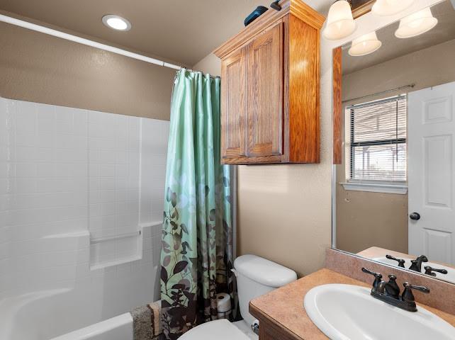792 County Road 4213 Decatur, TX 76234 - Photo 16 of 32 Bathroom featuring vanity, shower / bath combo, recessed lighting, and a textured wall