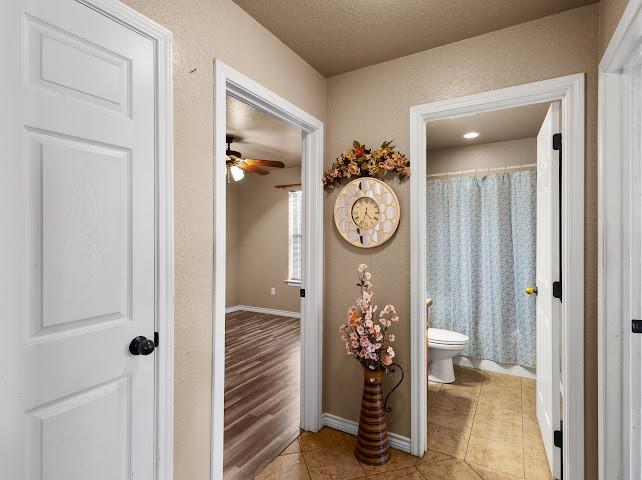 792 County Road 4213 Decatur, TX 76234 - Photo 19 of 32 Full bath featuring curtained shower, light tile patterned floors, a textured ceiling, ceiling fan, and a textured wall