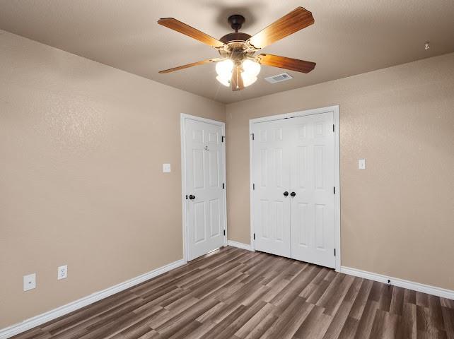 792 County Road 4213 Decatur, TX 76234 - Photo 20 of 32 Unfurnished bedroom featuring wood finished floors, ceiling fan, and a closet