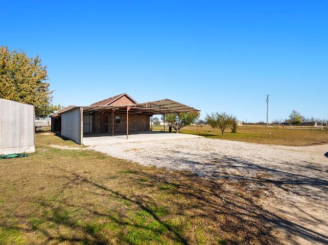 792 County Road 4213 Decatur, TX 76234 - Photo 29 of 32 View of yard featuring a carport, gravel driveway, and a rural view