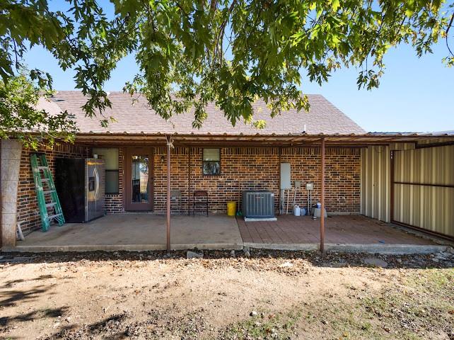 792 County Road 4213 Decatur, TX 76234 - Photo 30 of 32 Back of property with a patio, brick siding, and roof with shingles