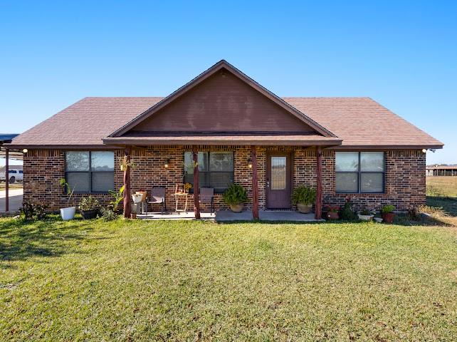 792 County Road 4213 Decatur, TX 76234 - Photo 3 of 32 View of front facade featuring brick siding, a front yard, a porch, and roof with shingles