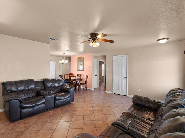 792 County Road 4213 Decatur, TX 76234 - Photo 6 of 32 Living area with a textured ceiling, a ceiling fan, a chandelier, and tile patterned flooring