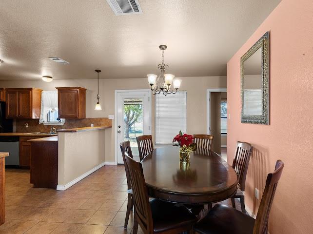 792 County Road 4213 Decatur, TX 76234 - Photo 7 of 32 Dining room featuring a chandelier, a textured ceiling, and light tile patterned flooring