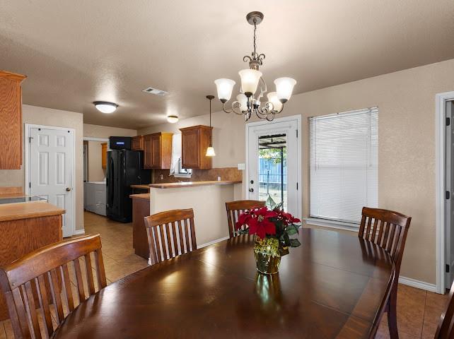 792 County Road 4213 Decatur, TX 76234 - Photo 8 of 32 Dining space featuring a chandelier, a textured ceiling, and light tile patterned floors