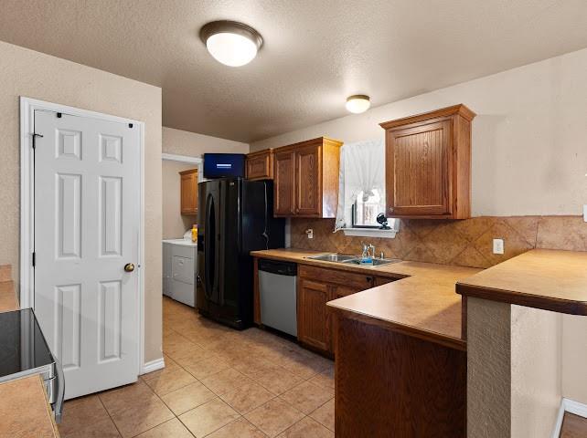 792 County Road 4213 Decatur, TX 76234 - Photo 10 of 32 Kitchen featuring a peninsula, brown cabinets, light countertops, a textured ceiling, and appliances with stainless steel finishes