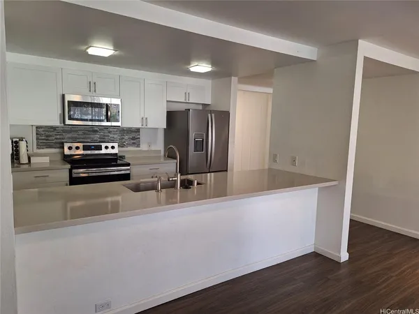 a kitchen with granite countertop a refrigerator and a stove top oven