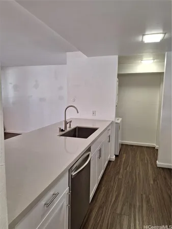 a kitchen with a sink and wooden floor
