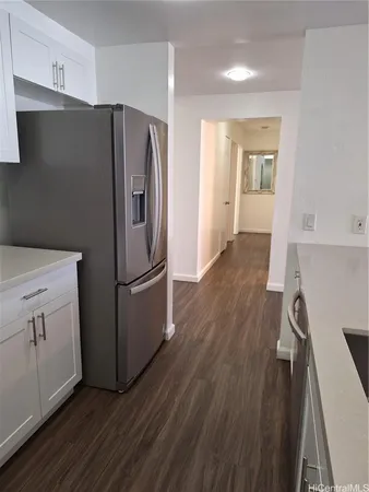 a kitchen with a refrigerator a sink and wooden floor