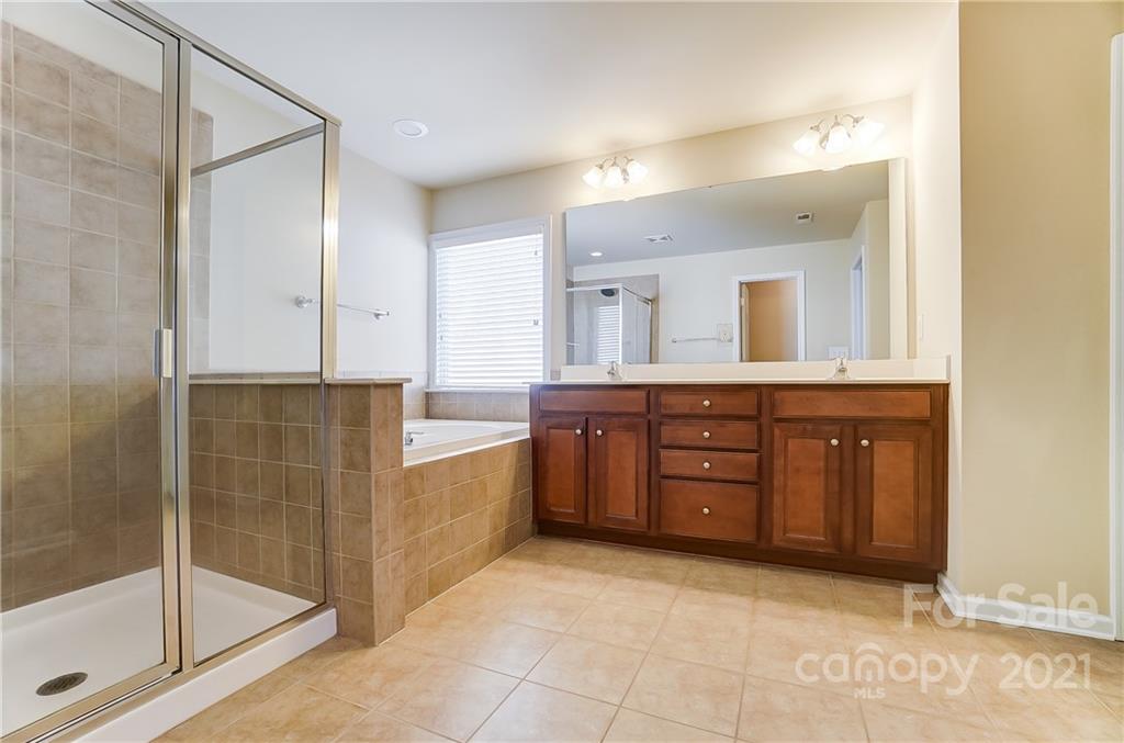 3438 Richard's Crossing Fort Mill, SC 29708 - Photo 22 of 41 a bathroom with a granite countertop sink a mirror and a shower