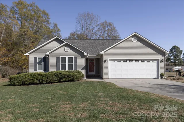 a view of a house with a yard and garage