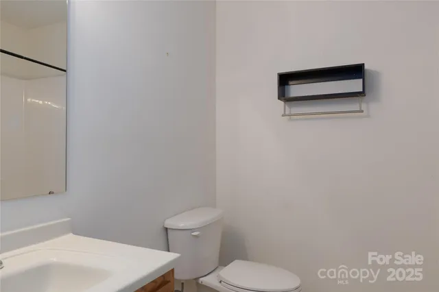 a white toilet sitting next to a white sink and vanity