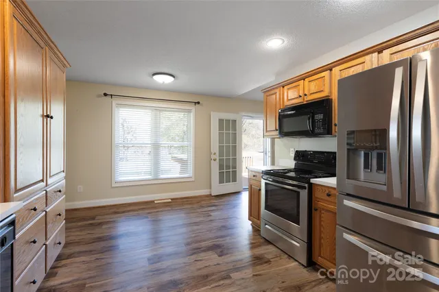 a kitchen with stainless steel appliances granite countertop a stove a sink and a refrigerator