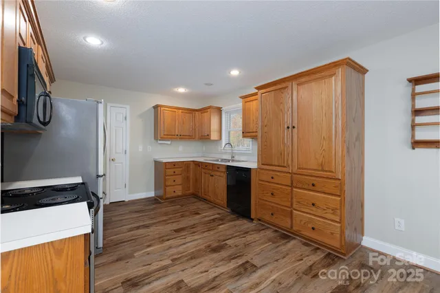 a kitchen with a refrigerator and a stove top oven