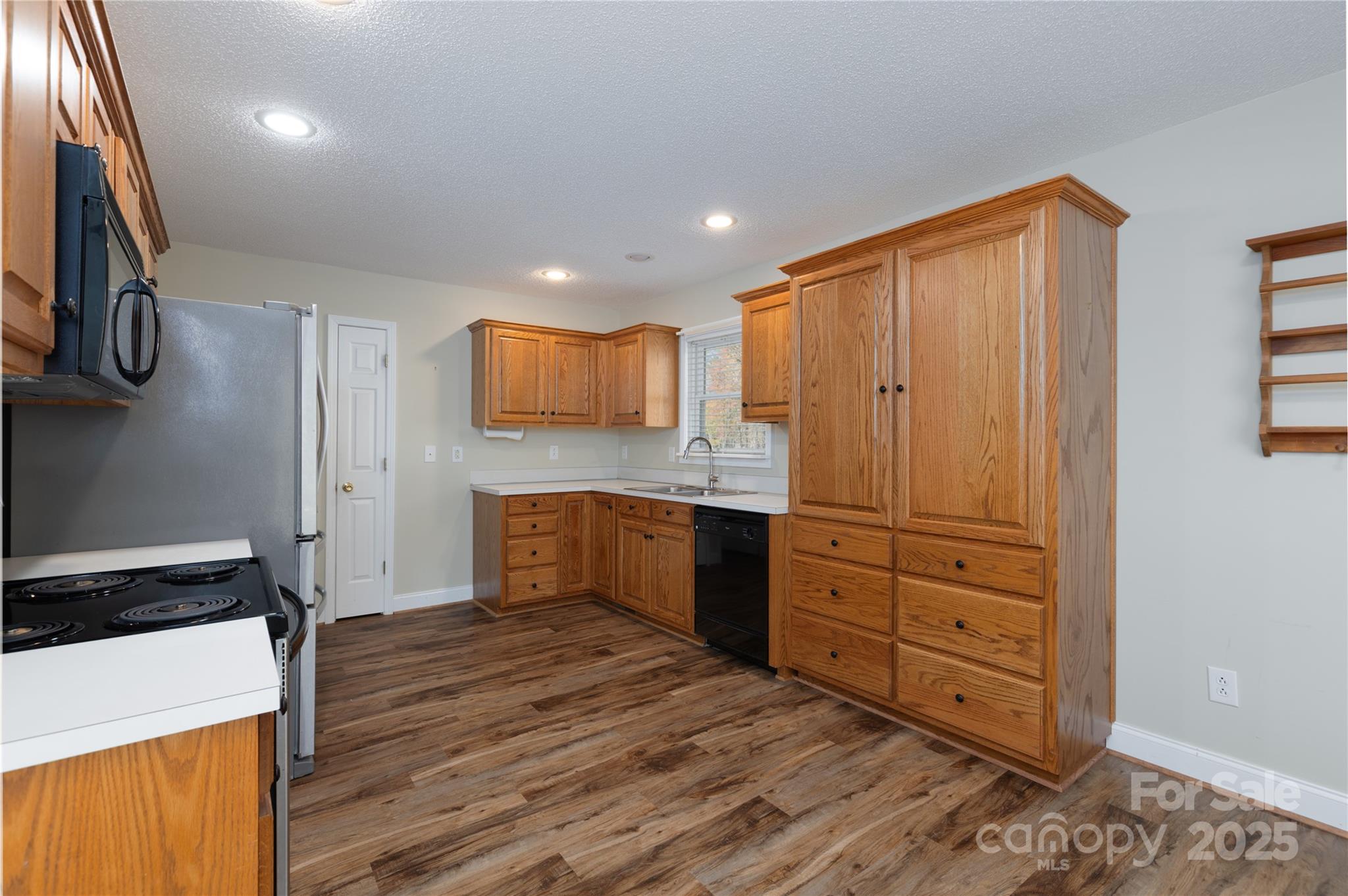 1505 Moss Springs Road Albemarle, NC 28001 - Photo 7 of 26 a kitchen with a refrigerator and a stove top oven