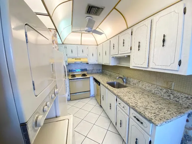 a kitchen with white cabinets and white appliances