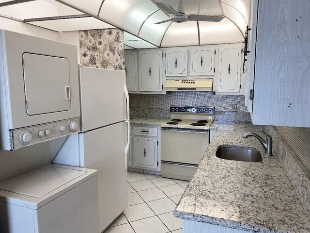 a kitchen with stainless steel appliances granite countertop a sink a stove and cabinets