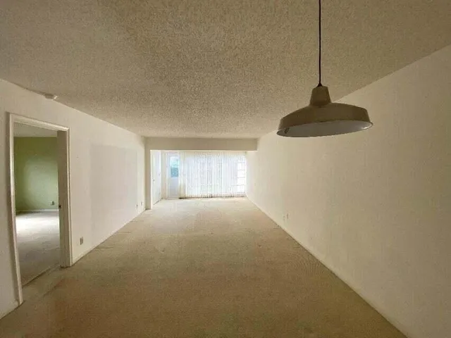 a view of empty room with a ceiling fan and window
