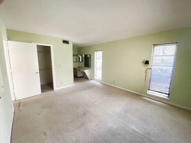 an empty room with windows and closet