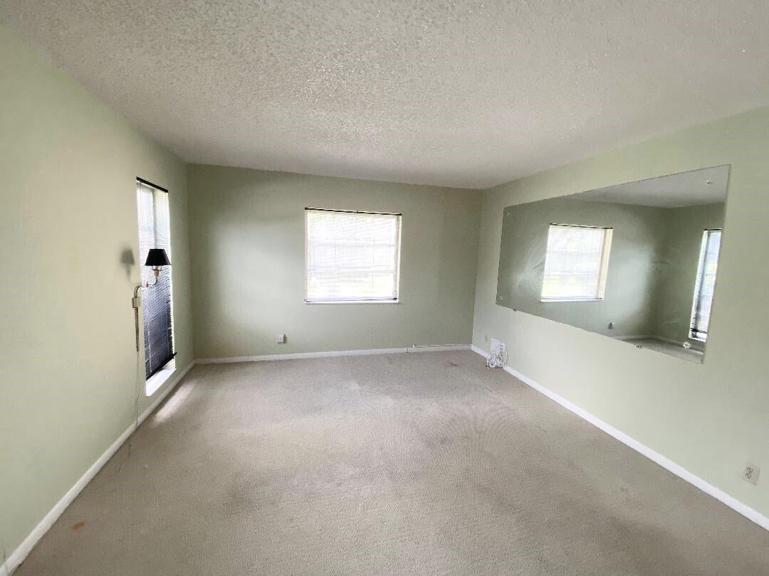 1141 Violet Terrace, Unit 101 Delray Beach, FL 33445 - Photo 9 of 29 an empty room with windows and closet