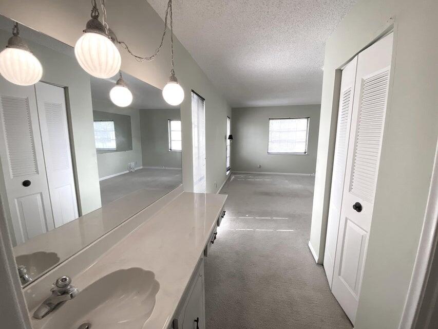 1141 Violet Terrace, Unit 101 Delray Beach, FL 33445 - Photo 10 of 29 a view of a bathroom from a hallway