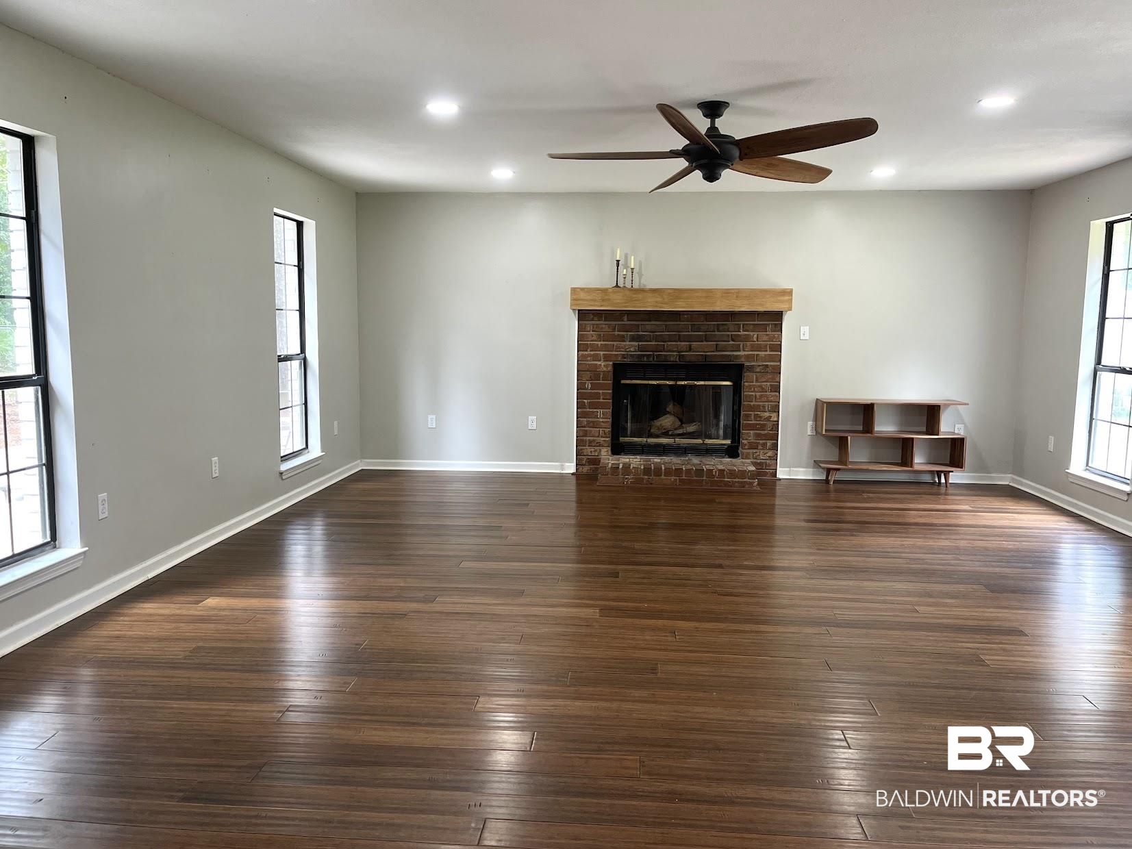 8450 Murray Road Irvington, AL 36544 - Photo 15 of 20 Unfurnished living room with a brick fireplace, ceiling fan, and dark hardwood / wood-style floors