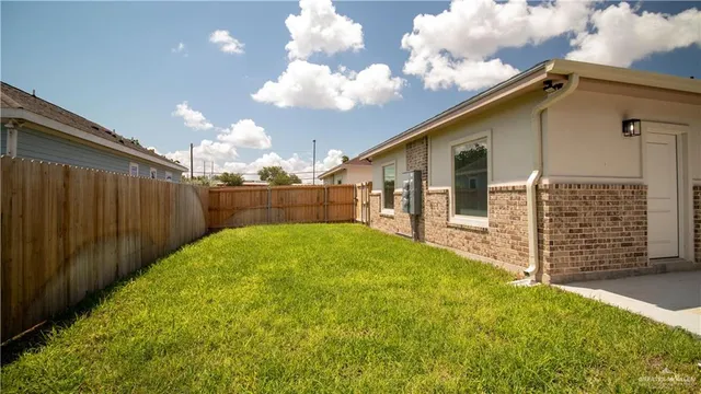 a view of a backyard with brick wall and wooden fence