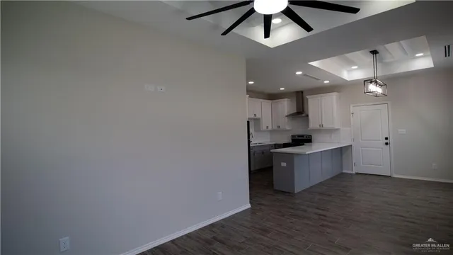 a large kitchen with a wooden floor and a ceiling fan