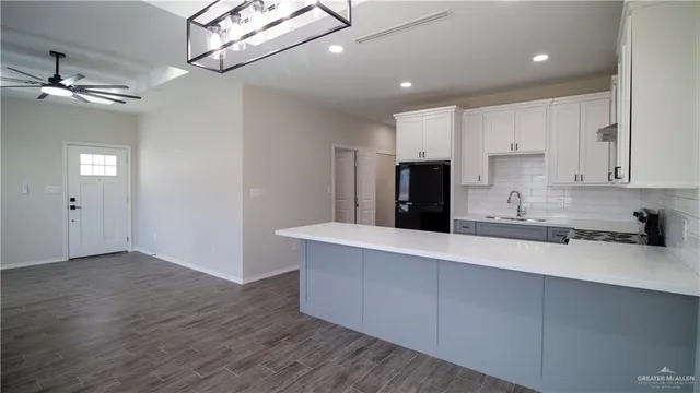 a kitchen with kitchen island a sink stainless steel appliances and cabinets