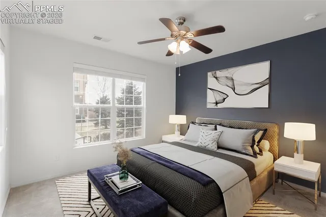 an empty room with chandelier fan and windows