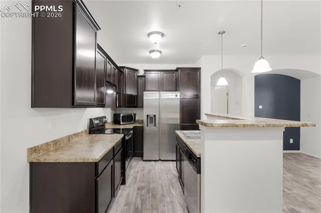 a kitchen with a sink a counter space and a chandelier