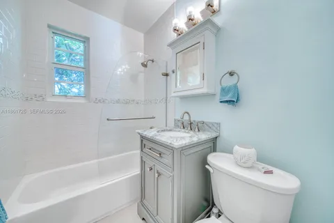 a bathroom with a granite countertop sink a toilet and bathtub