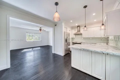 a kitchen with stainless steel appliances granite countertop wooden floors sink and cabinets