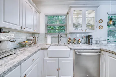 a kitchen with stainless steel appliances granite countertop a sink a stove and cabinets